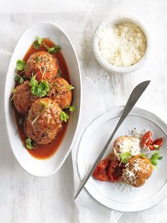 meatballs with tomato sauce and parmesan cheese are on the plate next to another dish