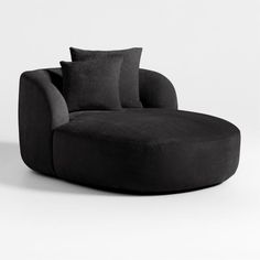 a large black couch with pillows on it's back and two sides facing each other