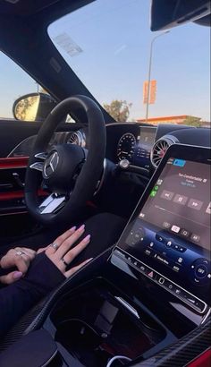 a woman is sitting in the driver's seat of a car with her hands on the steering wheel