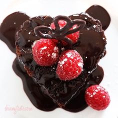 a piece of chocolate cake topped with raspberries on top of a white plate