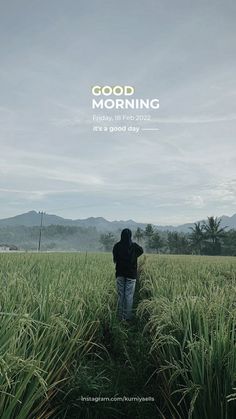 a man standing in the middle of a lush green field