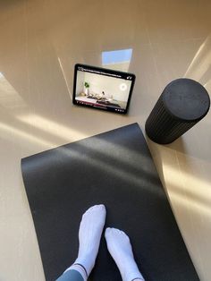 a person sitting on a yoga mat in front of a cell phone and an exercise mat