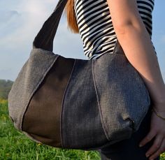 a woman carrying a black and white bag in her hands on a field with wildflowers