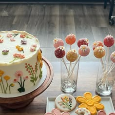 a table topped with lots of decorated cakes and cookies