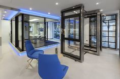 a room that has some blue chairs and glass doors on the walls in front of it