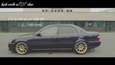 a black car with gold rims parked in front of a building