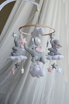 a baby mobile with elephants and stars hanging from it