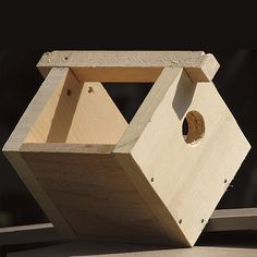 a wooden birdhouse sitting on top of a table