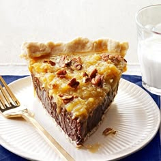 a piece of pie sitting on top of a white plate next to a glass of milk