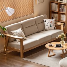 a living room with a couch, coffee table and bookshelf in the corner