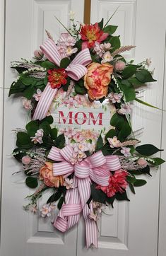 a mom's day wreath with pink and red flowers on the front door,