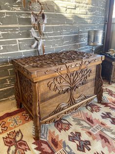 an ornate wooden chest in front of a brick wall with native american decor on it