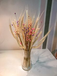 a vase filled with dried flowers on top of a table