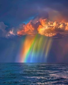 a rainbow is shining in the sky over the ocean