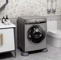 a washer sitting next to a toilet in a bathroom