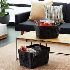 two black baskets sitting on top of a coffee table