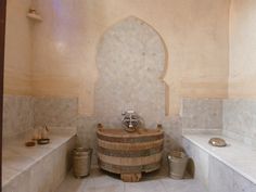 a bath room with a wooden barrel next to two sinks