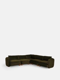 a green sectional couch with wooden legs