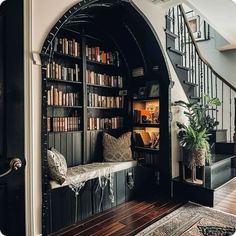 an entry way with bookshelves and stairs