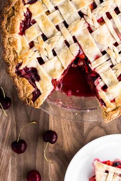 a pie on a table with cherries around it