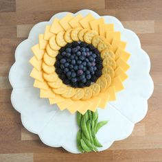 a cake decorated like a sunflower with grapes and crackers in the shape of a flower