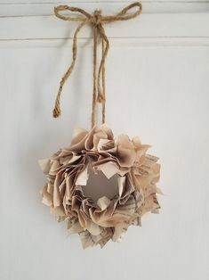 an ornament made out of old newspaper is hanging on a door with twine