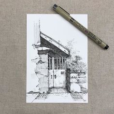 a pencil drawing of a small building with a door and steps leading to it on a piece of paper next to a marker