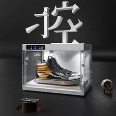 a pair of sneakers in a glass case with japanese characters on the wall behind them