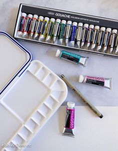 the contents of an art supply box including lip bales, glues and pens