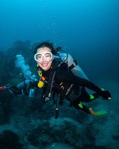 a woman scubas in the ocean with her mask on