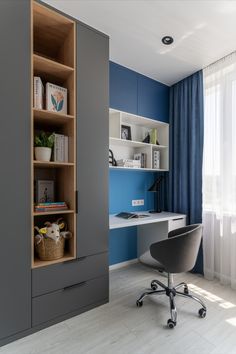 an office with blue walls and grey furniture in the corner, along with a white desk