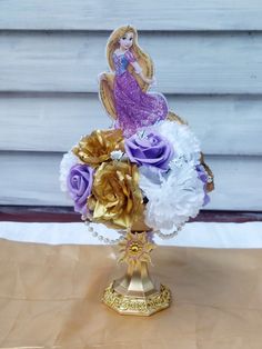 a gold vase filled with purple and white flowers