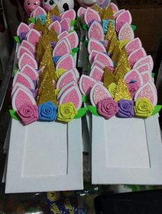 there are many decorated cookies in the shape of unicorns and roses on display for sale