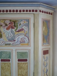 an ornate painted cabinet in the corner of a room