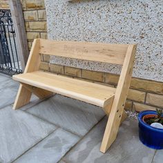 a wooden bench sitting next to a blue potted plant