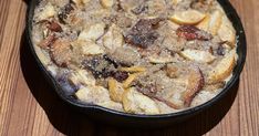 a pan filled with food sitting on top of a wooden table