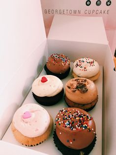 a box filled with lots of different flavored cupcakes