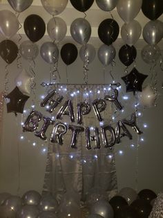 a birthday party with balloons and streamers in the shape of letters that read happy birthday