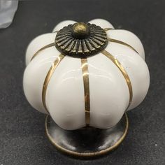 a white and gold decorative object sitting on top of a table