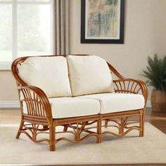 a wicker couch sitting on top of a rug in a living room next to a window