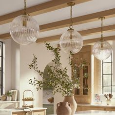 a kitchen filled with lots of counter top space and hanging lights over the stovetop