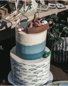 a three tiered cake decorated with an image of a boat and other things on it