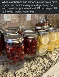 jars filled with cherries and lemons are on the counter