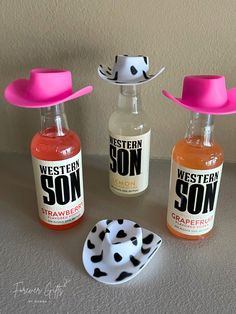 three bottles with hats on top of them