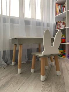 a child's table and chair in front of a window