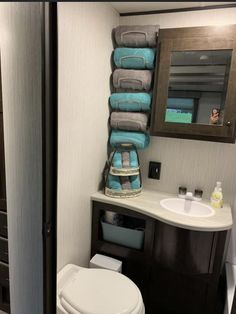 a bathroom with a toilet, sink and towel rack