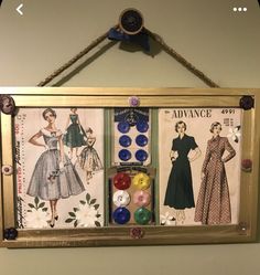 an old fashion sewing pattern hanging on the wall with buttons and pins attached to it