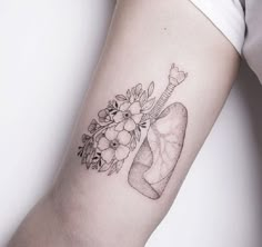 a woman's arm with a tattoo on it that has flowers and a tube in it