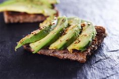 bread with sliced up avocado on it and seasoning sprinkled on top