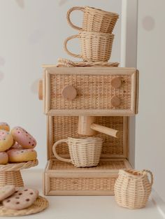 a stack of wicker baskets with coffee cups on top and cookies next to it